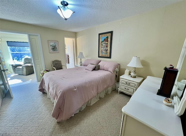 bedroom featuring light colored carpet and a textured ceiling