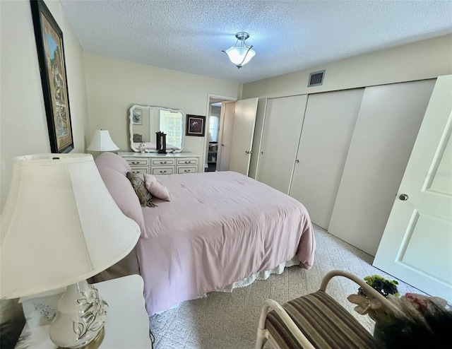 bedroom with a textured ceiling and a closet