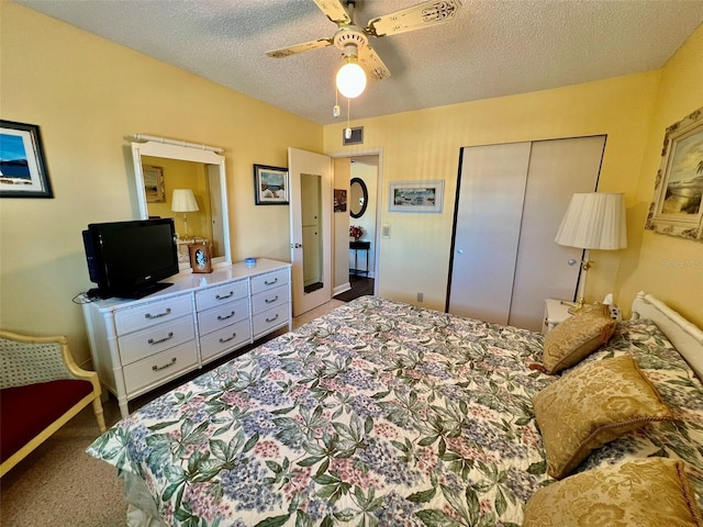 carpeted bedroom featuring a textured ceiling, ceiling fan, and a closet