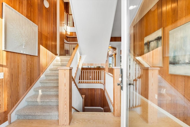 stairs featuring wood walls