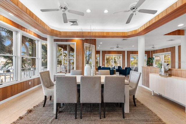 dining area featuring recessed lighting, light wood-type flooring, visible vents, and wood walls