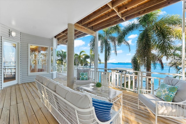 wooden deck featuring a water view and outdoor lounge area