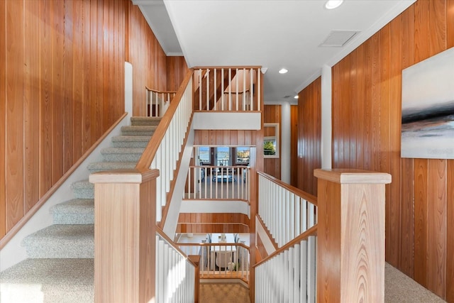 stairway with carpet floors and wood walls