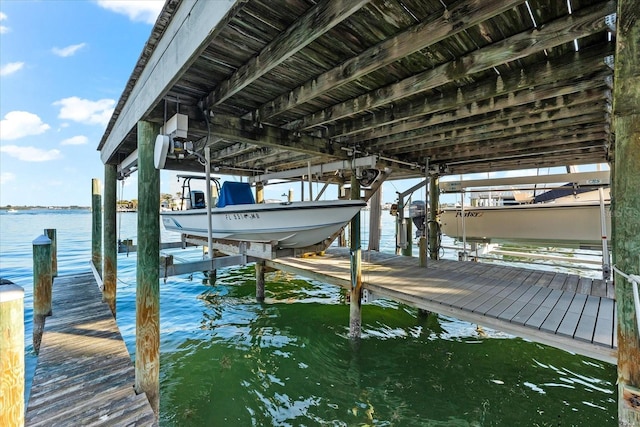 dock area featuring boat lift and a water view