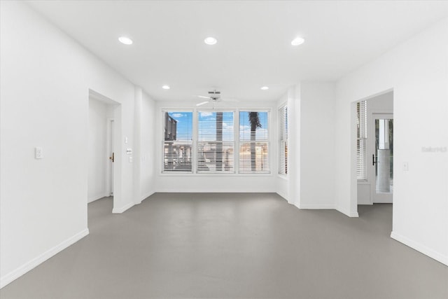 empty room with a ceiling fan, recessed lighting, finished concrete flooring, and baseboards