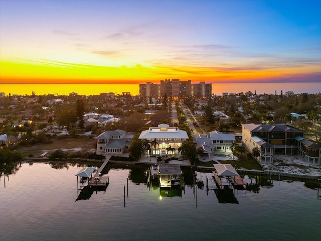 aerial view at dusk featuring a water view