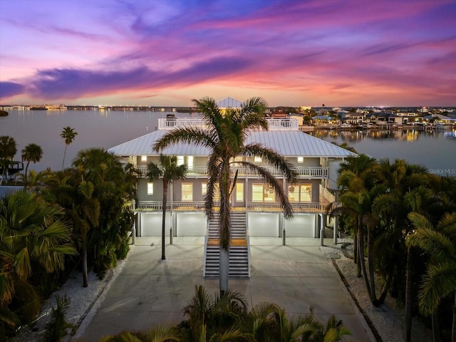 view of property's community featuring an attached garage, concrete driveway, and a water view