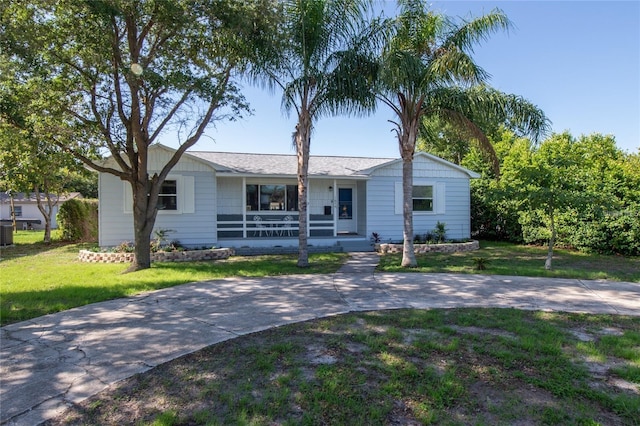 ranch-style house featuring covered porch and a front lawn