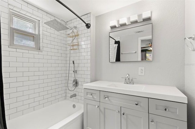 bathroom featuring tiled shower / bath and vanity