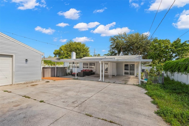 back of property with a hot tub