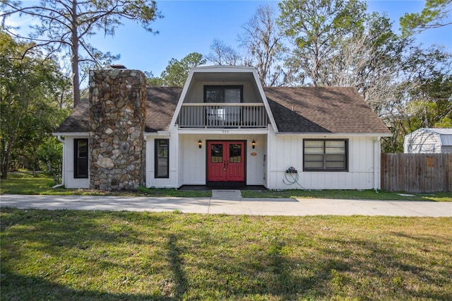 view of front of house featuring a balcony and a front yard