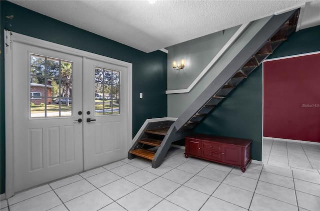 tiled foyer featuring a textured ceiling and french doors