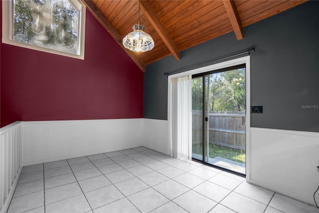 tiled spare room with a chandelier, wooden ceiling, and vaulted ceiling with beams