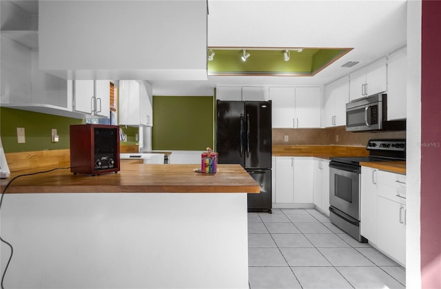 kitchen featuring white cabinets, stainless steel appliances, butcher block countertops, and kitchen peninsula