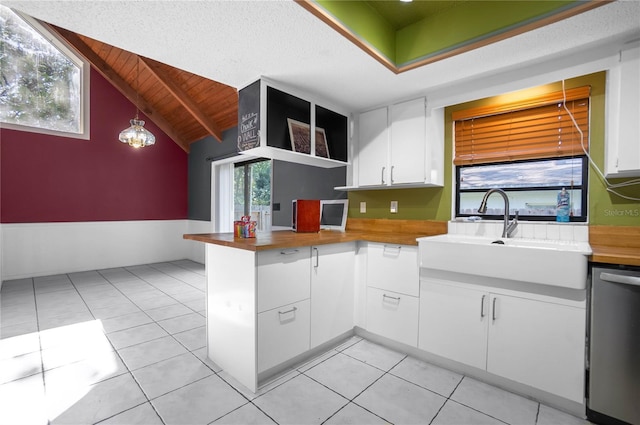 kitchen featuring white cabinets, dishwasher, butcher block countertops, and pendant lighting