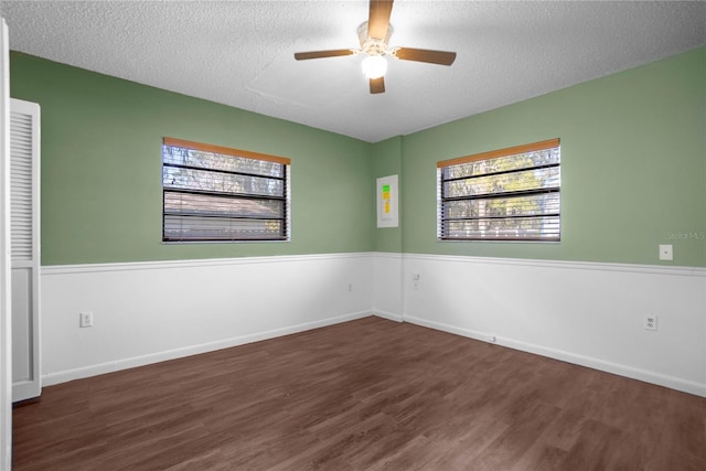 unfurnished room with dark hardwood / wood-style flooring, a textured ceiling, and ceiling fan