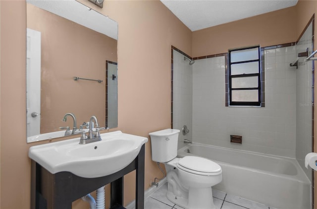 full bathroom featuring toilet, tiled shower / bath, tile patterned floors, and sink