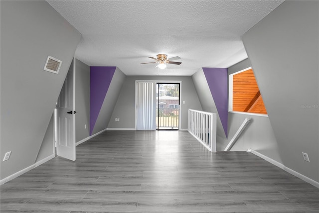 bonus room featuring a textured ceiling and ceiling fan