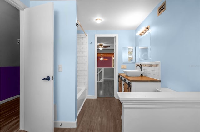 bathroom with ceiling fan, vanity, hardwood / wood-style floors, and bathtub / shower combination