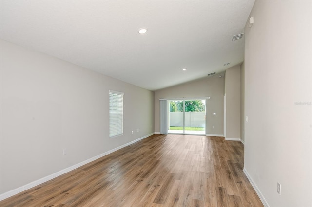 unfurnished room with visible vents, baseboards, light wood-style flooring, vaulted ceiling, and recessed lighting