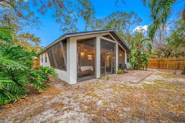 back of house featuring a sunroom and a patio