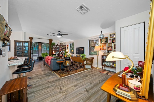 living room featuring hardwood / wood-style flooring, ceiling fan, and lofted ceiling