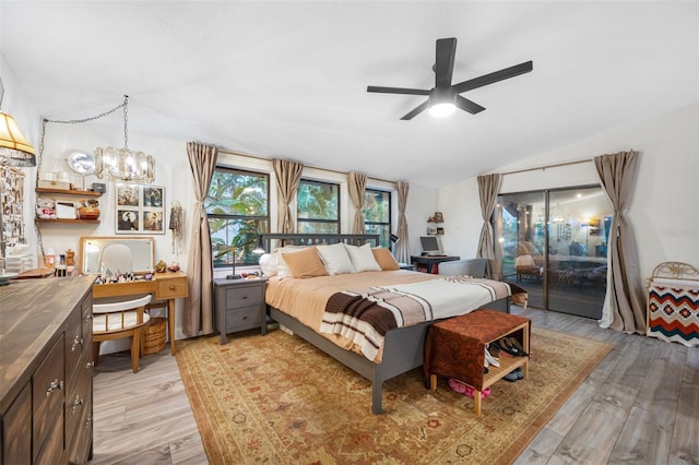 bedroom with ceiling fan with notable chandelier, lofted ceiling, access to outside, and light hardwood / wood-style flooring