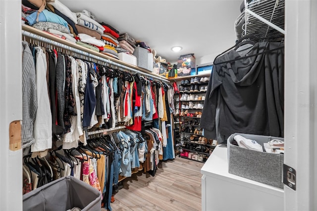 walk in closet with light hardwood / wood-style floors