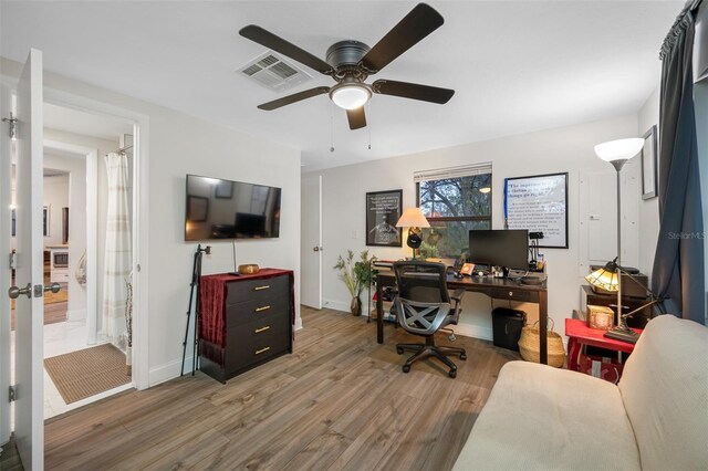 home office with hardwood / wood-style flooring and ceiling fan