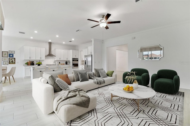 living room featuring crown molding and ceiling fan