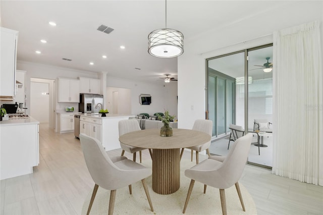 dining space with ceiling fan and ornamental molding