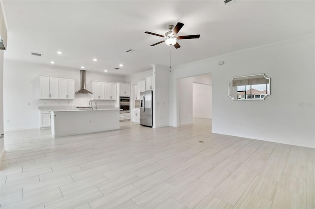 unfurnished living room with crown molding, sink, and ceiling fan