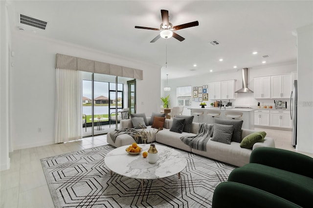 living room with crown molding and ceiling fan