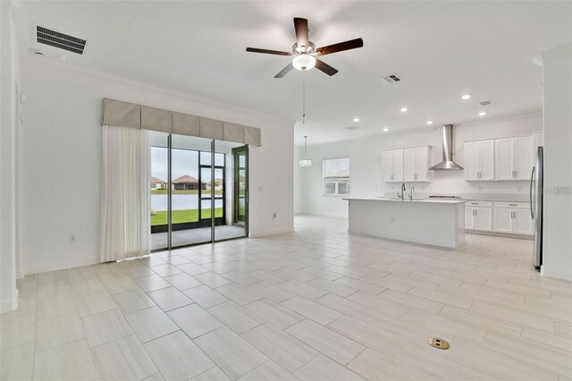 unfurnished living room with ceiling fan and ornamental molding