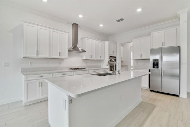 kitchen with sink, stainless steel appliances, white cabinets, a center island with sink, and wall chimney exhaust hood