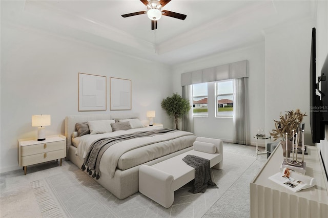 bedroom with ornamental molding, light carpet, ceiling fan, and a tray ceiling