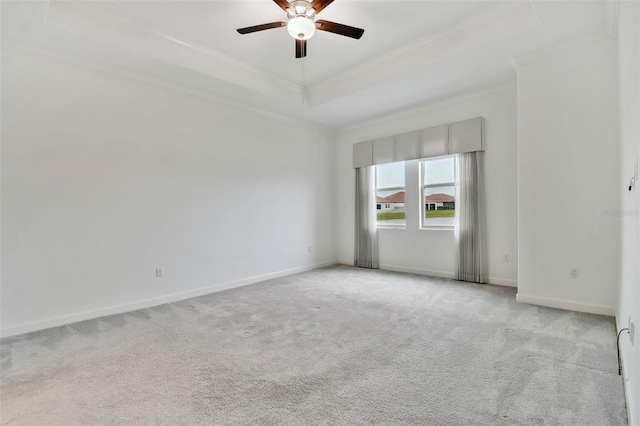 unfurnished room with ornamental molding, light colored carpet, a raised ceiling, and ceiling fan