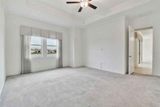 carpeted empty room with crown molding, ceiling fan, and a tray ceiling