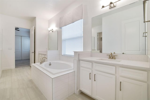 bathroom with a relaxing tiled tub and vanity