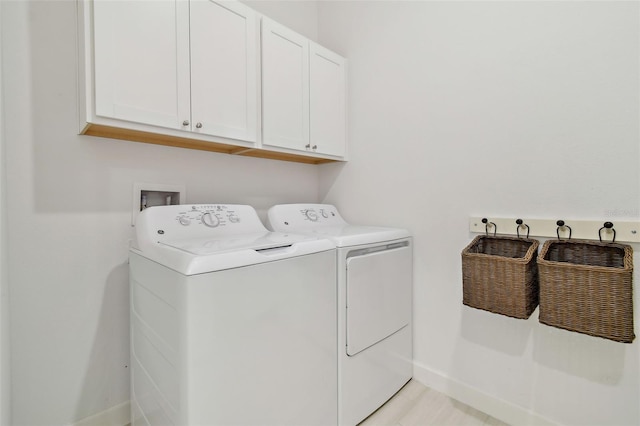 laundry area featuring separate washer and dryer and cabinets