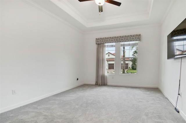 carpeted empty room with crown molding, ceiling fan, and a raised ceiling