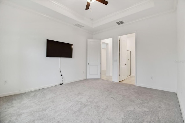 carpeted spare room featuring crown molding, ceiling fan, and a tray ceiling