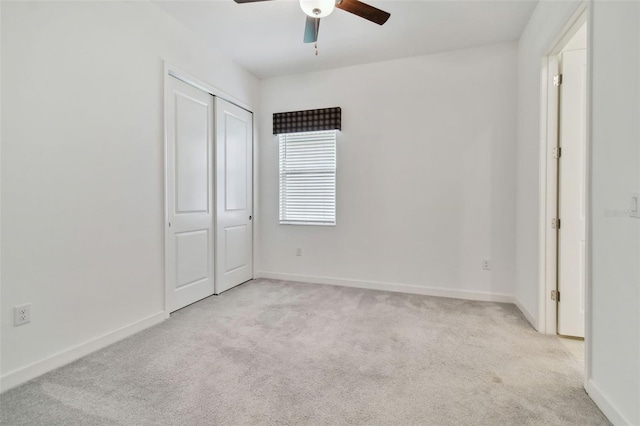 unfurnished bedroom featuring light carpet, ceiling fan, and a closet