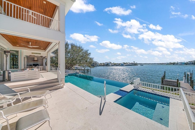 view of swimming pool featuring an in ground hot tub, a patio, a water view, and ceiling fan