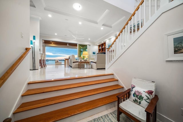 stairs with ceiling fan and ornamental molding