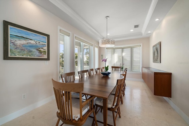 dining area featuring light tile patterned floors and a tray ceiling