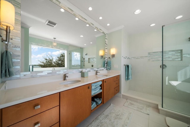 bathroom featuring tiled shower, vanity, crown molding, and tile patterned flooring