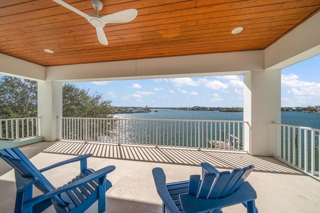 view of patio featuring ceiling fan, a balcony, and a water view