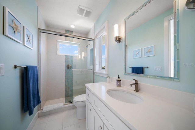 bathroom featuring tile patterned floors, vanity, a shower with shower door, and toilet