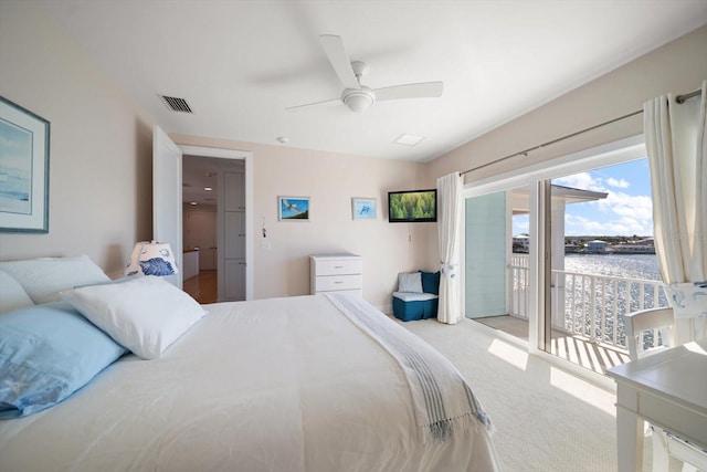 carpeted bedroom featuring ceiling fan, a water view, and access to outside